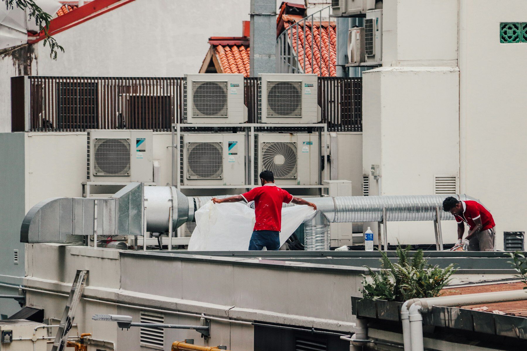 Techniekers bij koelinstallaties op een dak