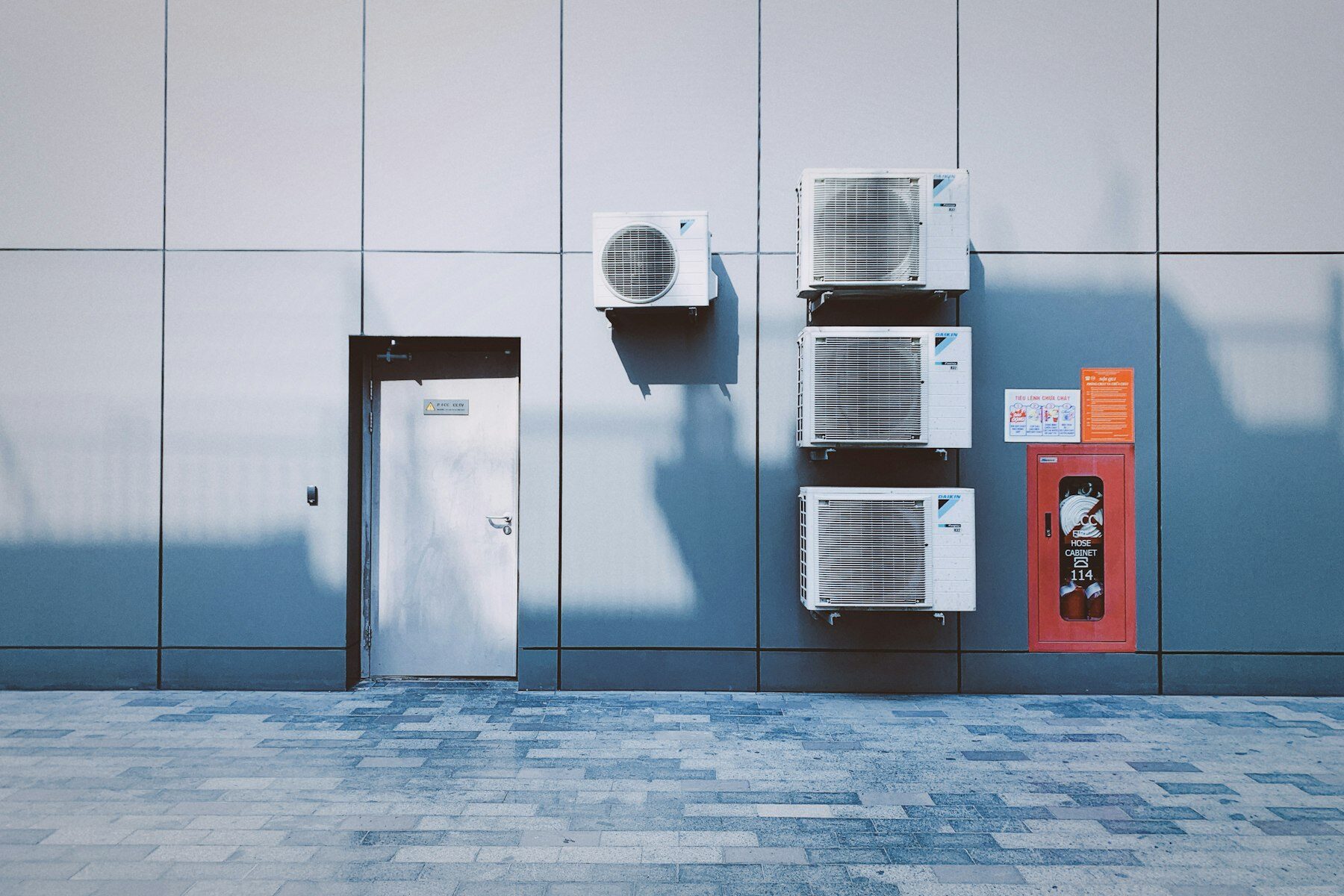 Airco-buitenunits tegen een bedrijfsgevel
